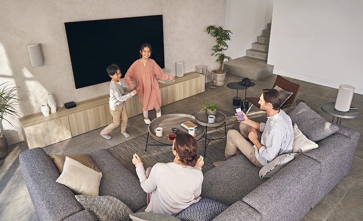 Family enjoying music from a variety of different sitting and standing positions in the room