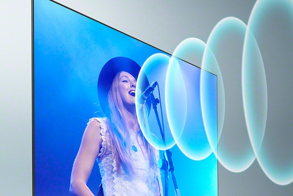 TV showing a woman singing with sound waves coming from the microphone on screen